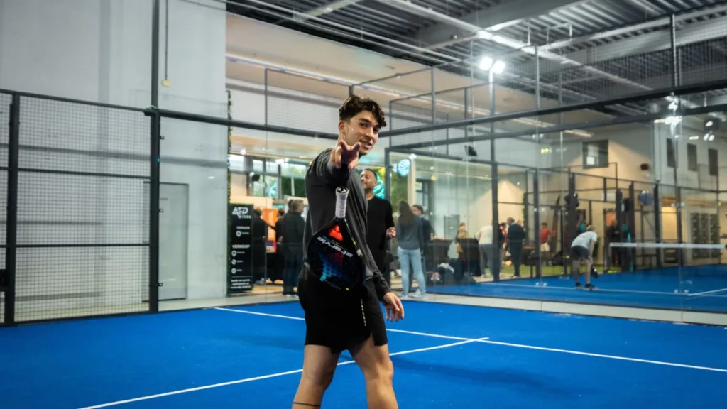 Padelspeler wijst naar de camera na een overwinning bij padel 1 tegen 1